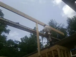 Carpenter setting a ridge beam over a new addition frame — Ice Dam Removal by Roofing Brothers in Worthing