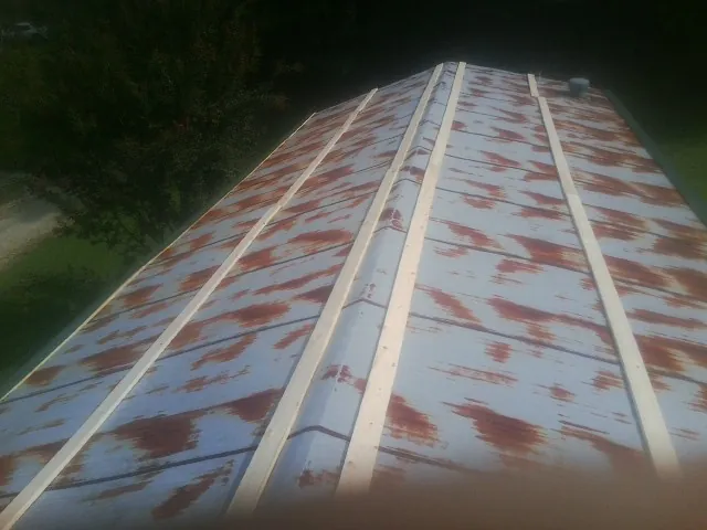 Rusted metal roof panels with new wood purlins before replacement — Storm Damage Roof Repair in Worthing by Roofing Brothers